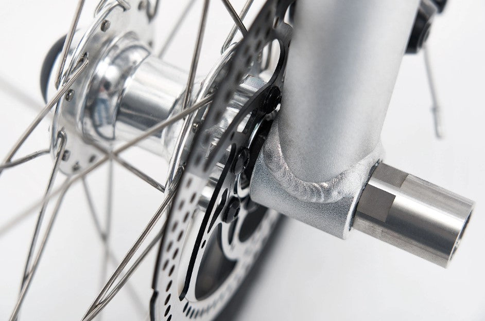 Iruka C Ebike's front wheel detail, featuring disc brake and dynamic hub.