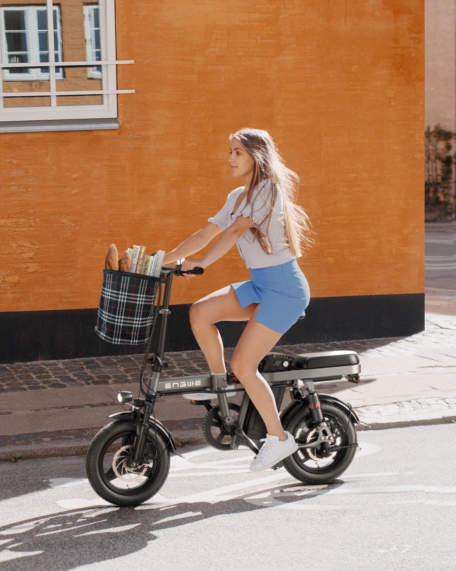 Woman riding Engwe T14 ebike on city street, exemplifying the bike's practicality for urban environments and stylish living.