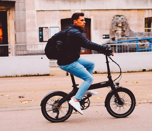 A stylish man riding the Eole electric bike across the city.