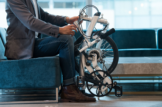 A man waiting at the seat with a folded Iruka S Japanese folding bike.