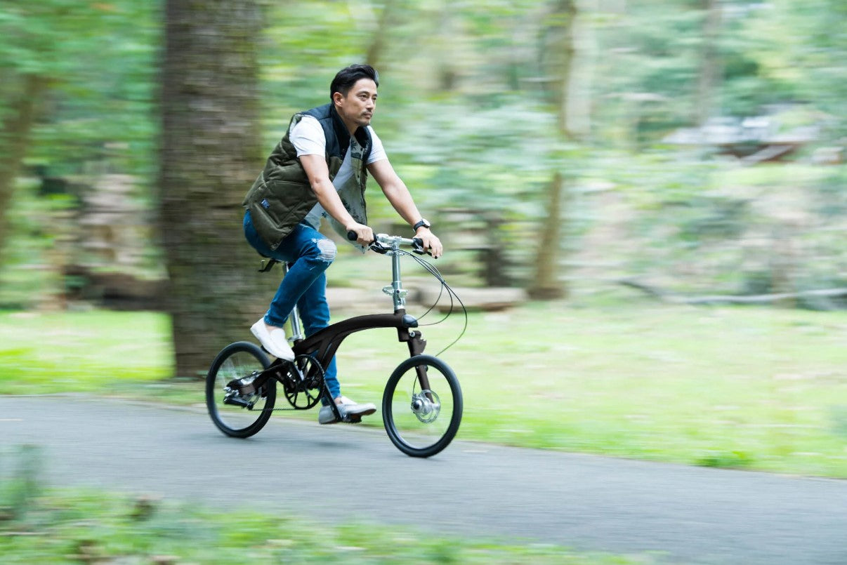 A man riding the Iruka S bicycle in the woods.