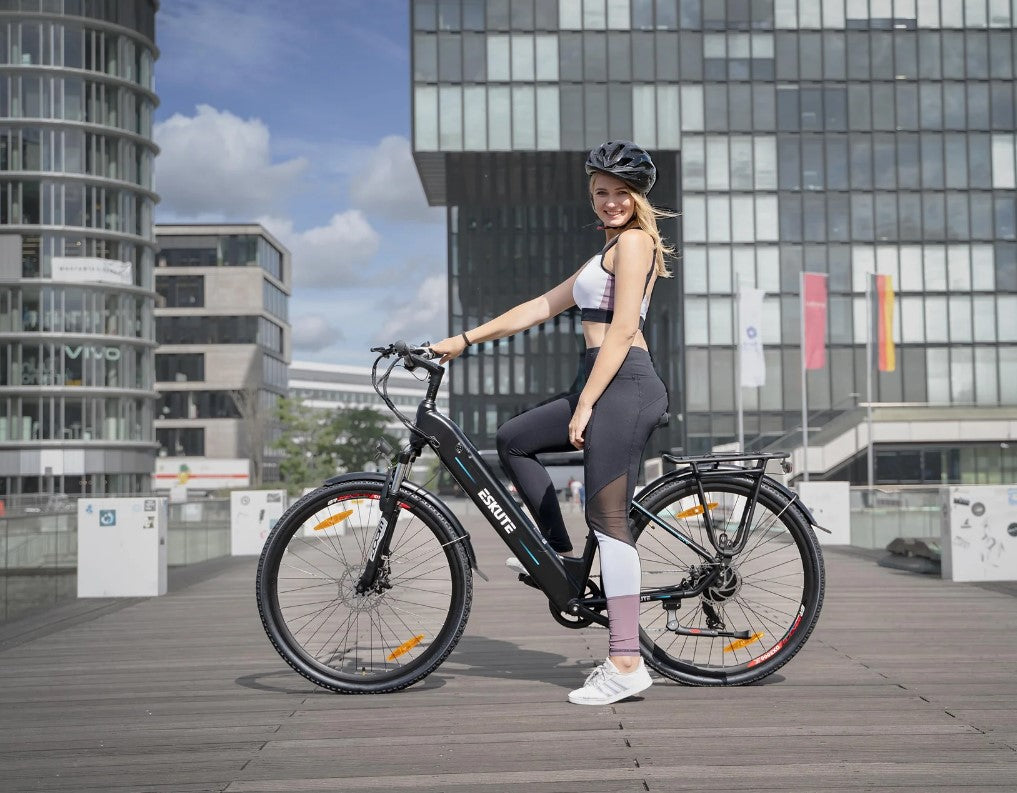 Smiling woman standing with an Eskute Polluno eBike in an urban environment.