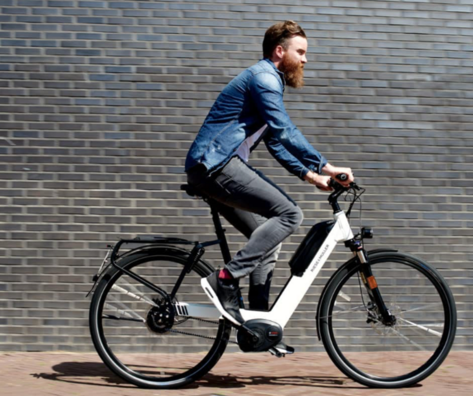 Active man riding a Mica-G electric bike in an urban setting, highlighting the bike's mobility and style.