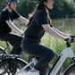 Couple enjoying a ride on Mica-G ebikes in a natural park setting, reflecting the bikes' suitability for recreational use.