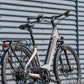 Deruiz Quartz e-bike leaning against a corrugated metal wall, emphaising urban style.