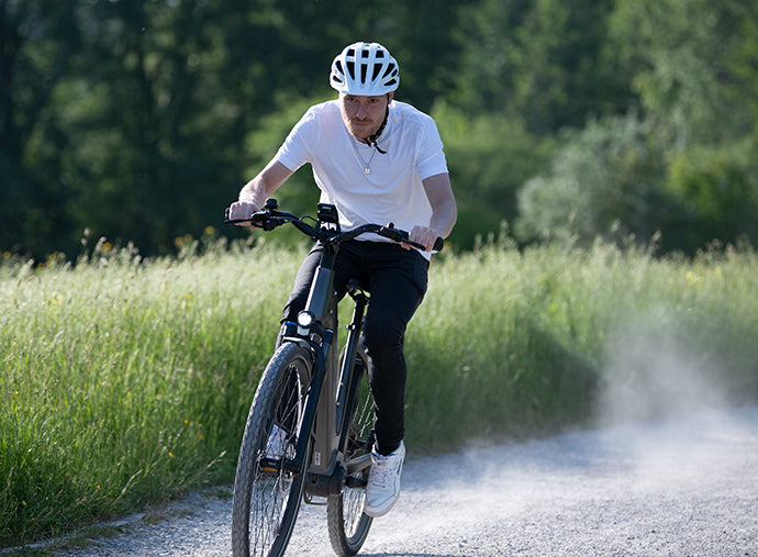 Man enjoying a ride through a rural trail on a Deruiz Marble electric bike, illustrating the versatility and power of eco-conscious transportation.