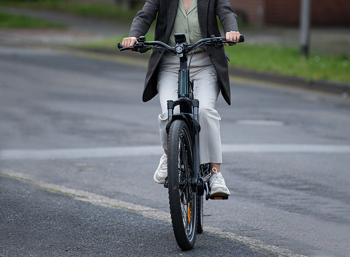 Woman riding the Lapis ebike on a city street, demonstrating the comfort and urban appeal of this modern electric bicycles.