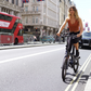 Confident woman cycling on a black Eole X ebike through a busy city street, illustrating the bike's urban functionality and style.